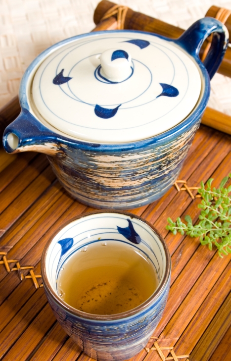 Feel Good Group - Teapot and mug of green tea on a bamboo tray.